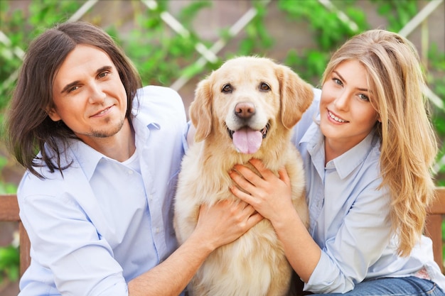 Coppia felice che abbraccia labrador retriever