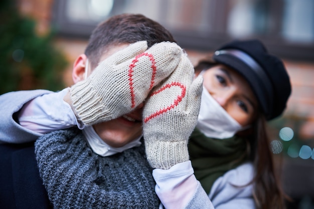 Coppia felice che celebra San Valentino in maschera durante la pandemia di covid-19 in città