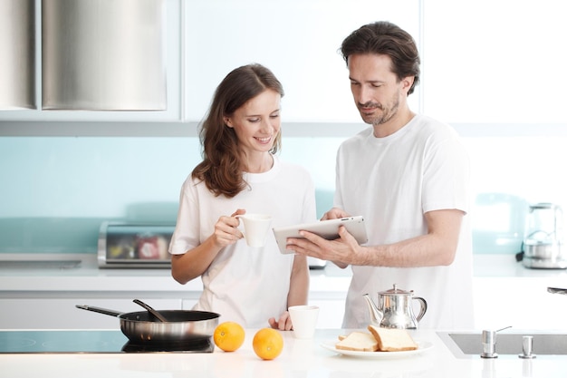 Coppia felice che cucina insieme la colazione in cucina