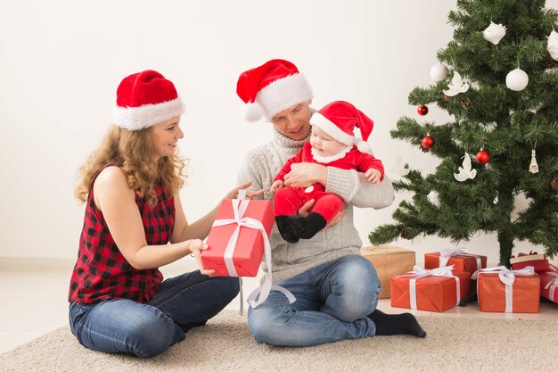 Coppia felice con bambino che celebra insieme il Natale a casa.