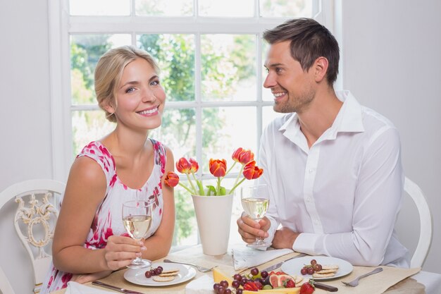 Coppia felice con bicchieri di vino con cibo