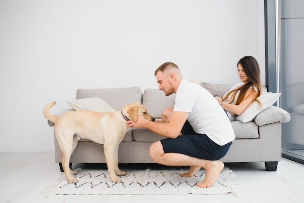 Coppia felice con il cane in soggiorno