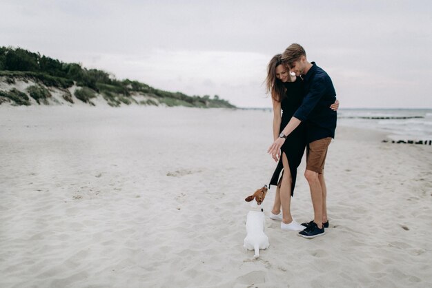 Coppia felice con il loro cane su una spiaggia