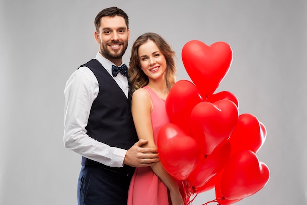 coppia felice con palloncini a forma di cuore rosso