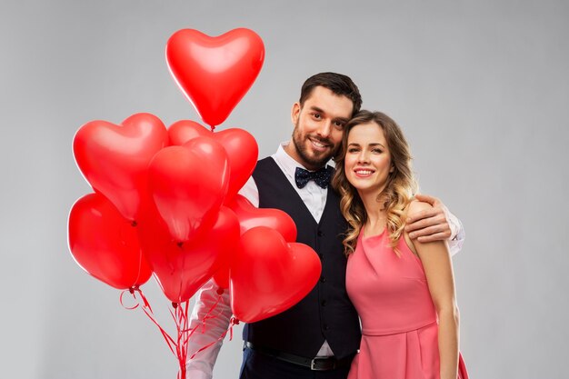 coppia felice con palloncini a forma di cuore rosso