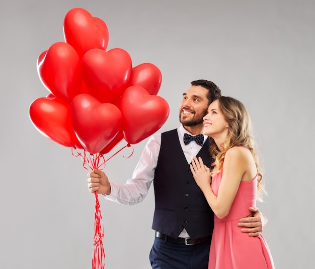 coppia felice con palloncini a forma di cuore rosso