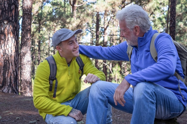 Coppia felice di nonno e nipote adolescente che fanno escursioni in montagna condividendo la stessa passione per la natura e uno stile di vita sano insieme nei boschi Adventureisageless