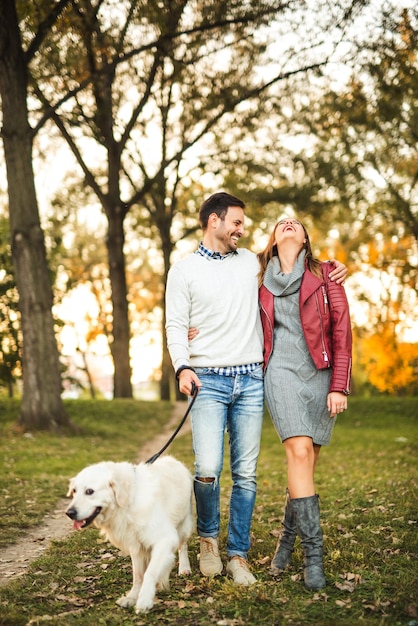 Coppia felice godendo di una passeggiata con il loro cane