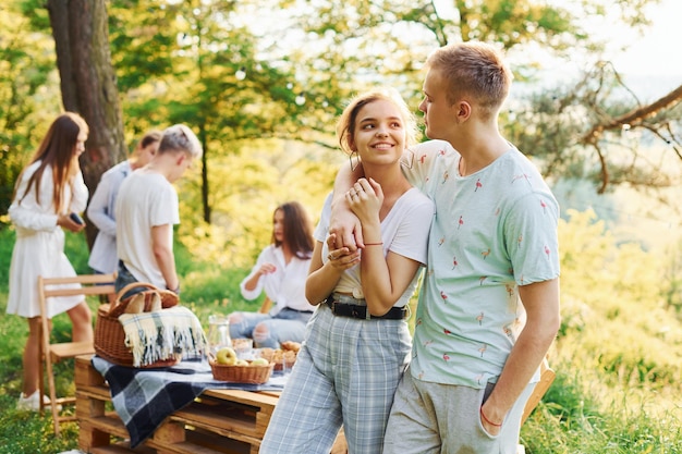 Coppia felice Gruppo di giovani in vacanza all'aria aperta nella foresta Concezione del fine settimana e dell'amicizia