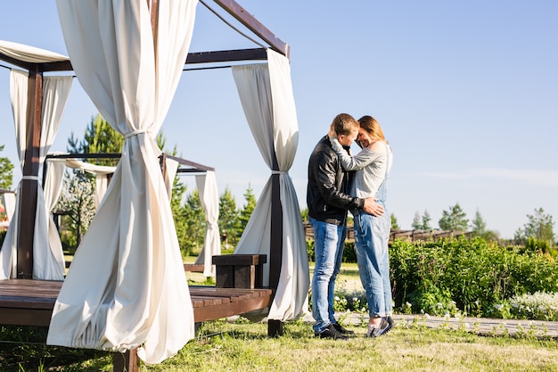 Coppia felice in attesa del bambino, donna incinta carina con il marito che si gode il clima primaverile, concetto di amore.