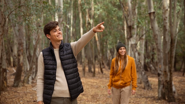 Coppia felice nella foresta camminando tra gli alberi