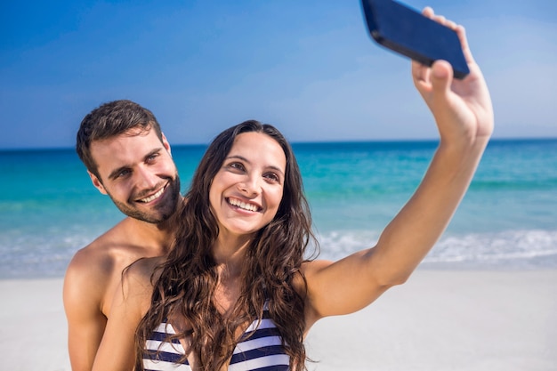 Coppia felice prendendo un selfie in spiaggia