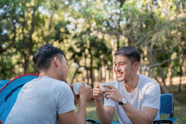 Coppia gay asiatica che viaggia con tenda, campeggio all'aperto e varie avventure, stile di vita, escursioni, vacanze estive attive, caffè e chiacchiere insieme.