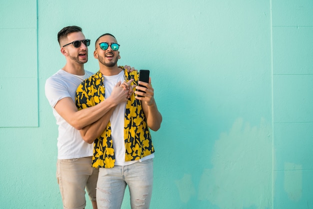 Coppia gay prendendo un selfie con il cellulare.