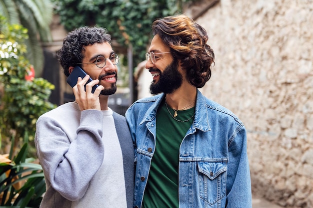 Coppia gay sorridendo felice e parlando al telefono