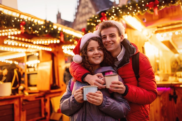 Coppia giovane con bevande sul mercatino di Natale a Wroclaw, Polonia