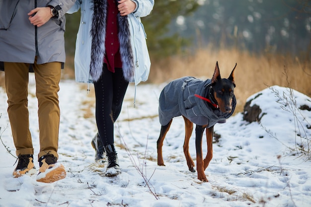 Coppia giovane con cane doberman all'aperto