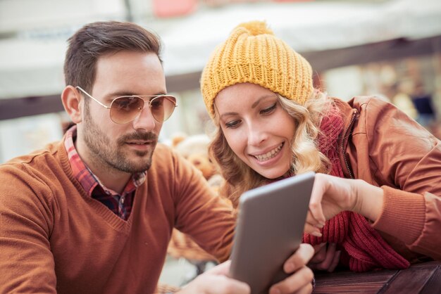 Coppia giovane con tavoletta digitale nella caffetteria