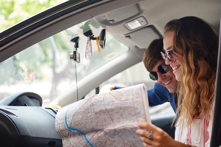 Foto coppia giovane controllando la mappa durante il viaggio