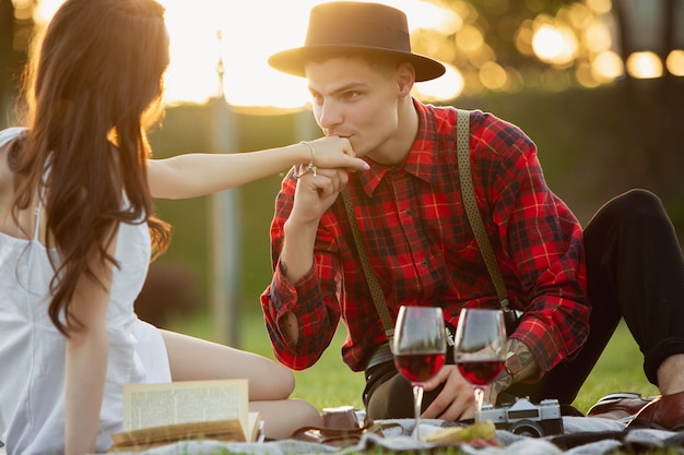 Coppia giovane e felice caucasica che si gode un picnic nel parco il giorno d'estate