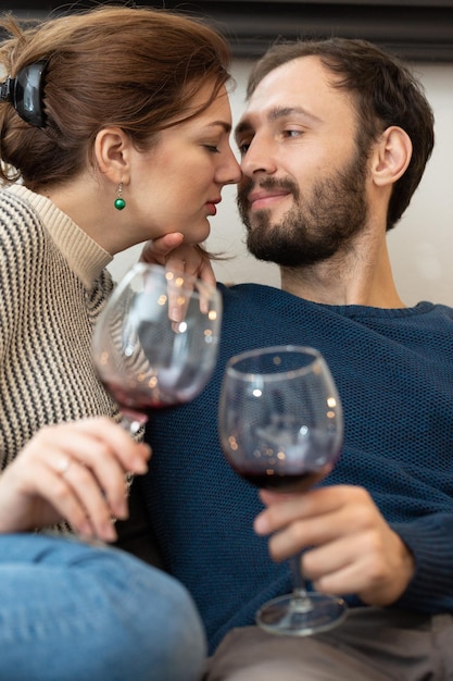 Coppia giovane e felice che beve vino e si rilassa a casa