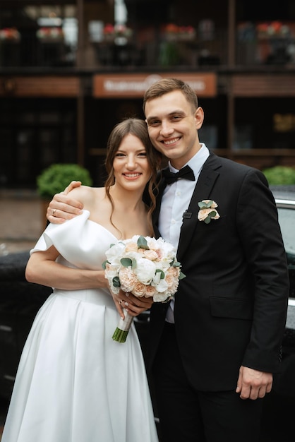 Coppia giovane sposa e sposo in un abito corto bianco