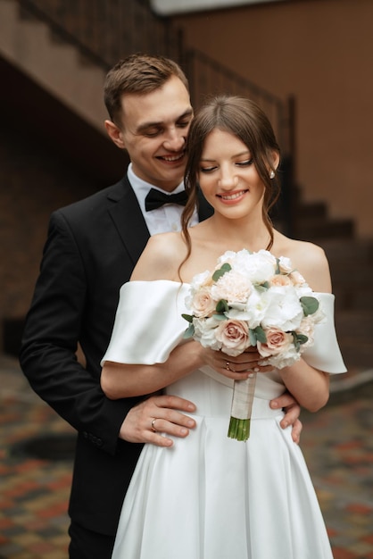 Coppia giovane sposa e sposo in un abito corto bianco