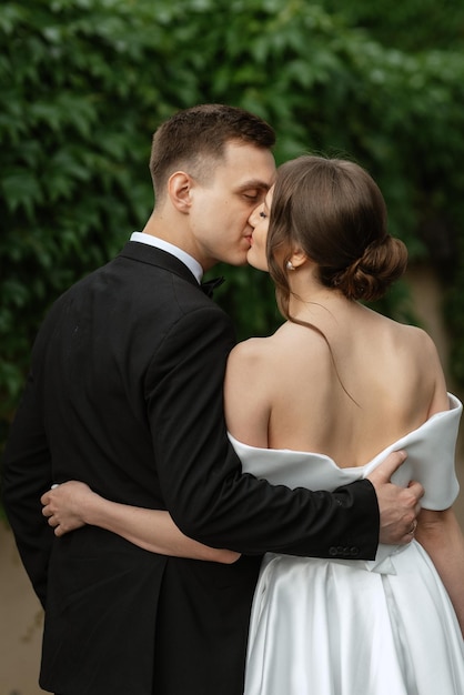 Coppia giovane sposa e sposo in un abito corto bianco