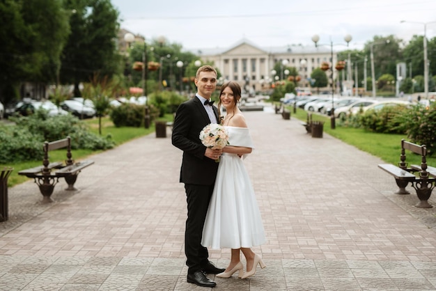 Coppia giovane sposa e sposo in un abito corto bianco