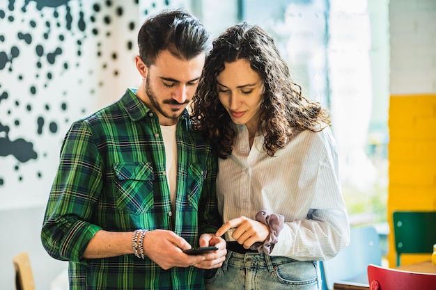 Coppia giovane utilizzando il proprio cellulare per navigare in internet