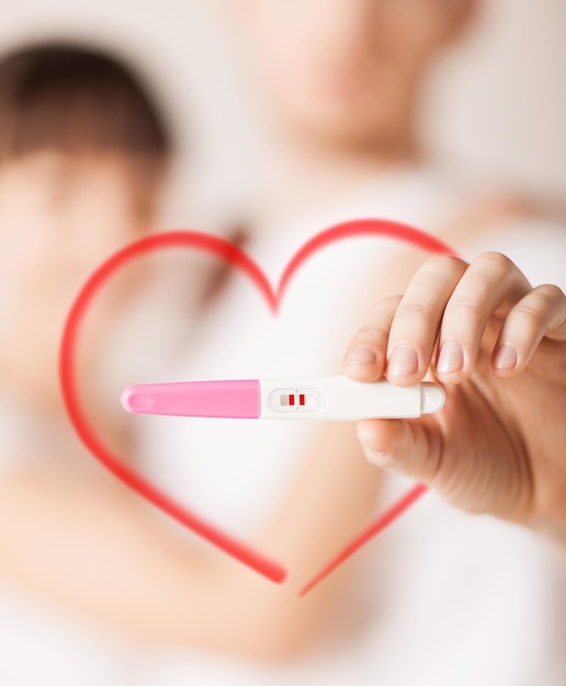 coppia, gravidanza e concetto di amore - primo piano delle mani di donna e uomo con test di gravidanza