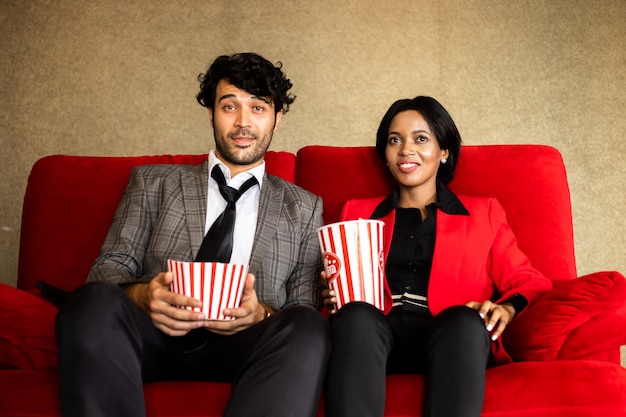 Coppia guardare film in teatro con popcorn sorriso e faccia felice