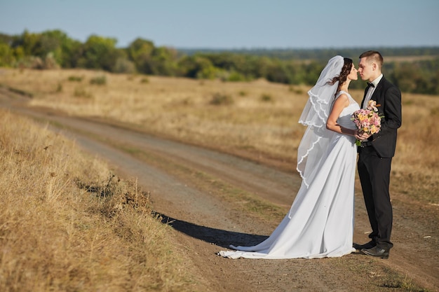 Coppia in abito da sposa con un mazzo di fiori