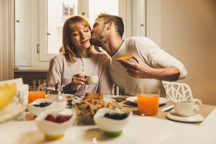 Coppia in amore a fare colazione la mattina presto in cucina a casa e divertirsi.
