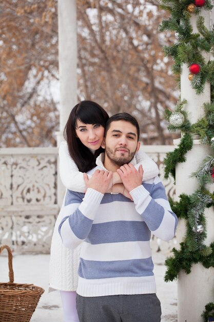 Coppia in amore che abbraccia nel gazebo decorato a Natale