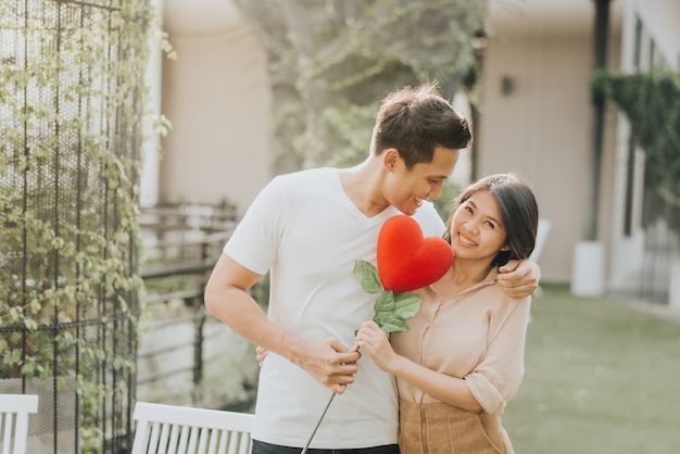 Coppia in amore divertendosi con il fiore del cuore