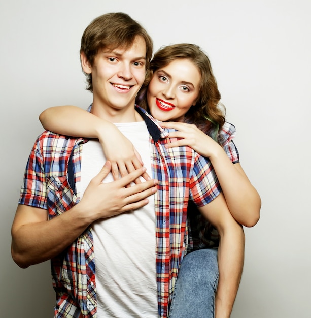 Coppia in amore Giovane donna e uomo che indossa abbigliamento casual su grigio.