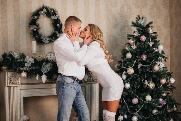 Coppia in amore tenere bacio sullo sfondo di un albero di Natale