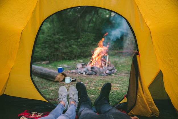 Coppia in appoggio in tenda con vista sul fuoco