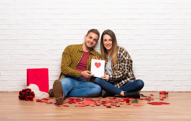 Coppia in giorno di San Valentino al chiuso con la carta di San Valentino