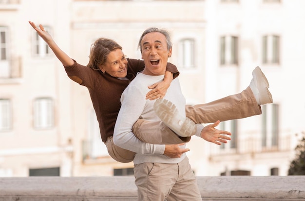 Coppia in pensione che condivide momenti di viaggio divertenti a Lisbona in posa all'aperto