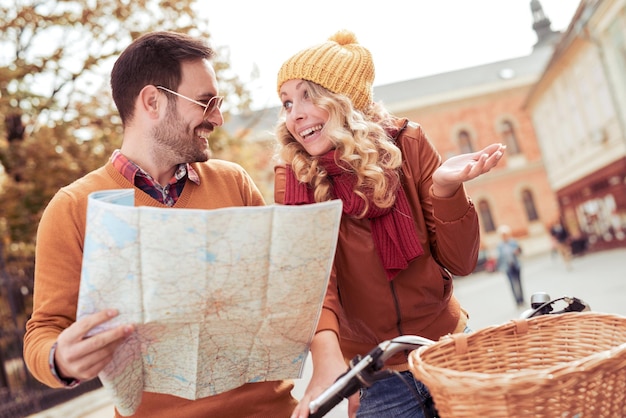 Coppia in sella a una bicicletta con mappa in città