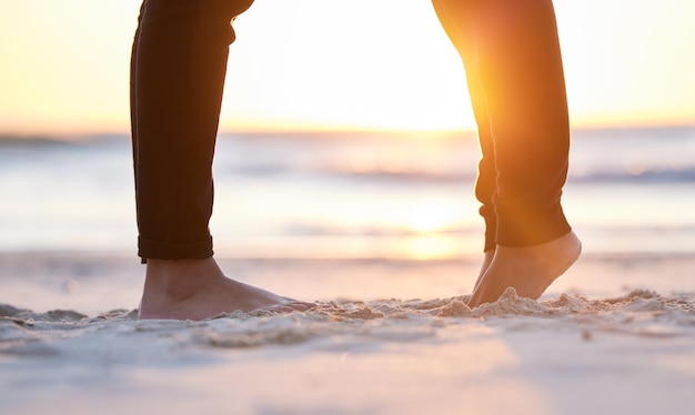 Coppia in spiaggia gambe e piedi nella sabbia all'alba amore e impegno nel rapporto con il viaggio Avventura insieme fiducia e rispetto cura in collaborazione e persone oceano con vacanza a Bali