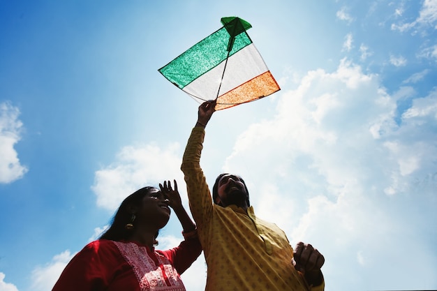 Coppia indiana che fa volare un aquilone tricolore della bandiera indiana
