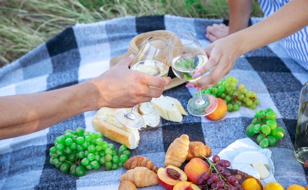 Coppia innamorata beve vino a un picnic. Messa a fuoco selettiva. Natura