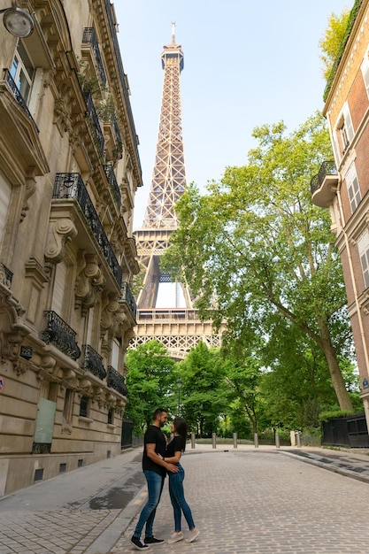 Coppia innamorata che si abbraccia e si guarda l'un l'altro con la torre eiffel a Parigi