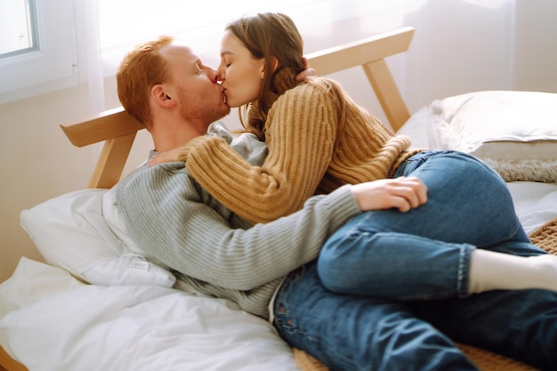 Coppia innamorata che si rilassa a casa sul letto mentre si abbracciano Concetto di vacanza di San Valentino