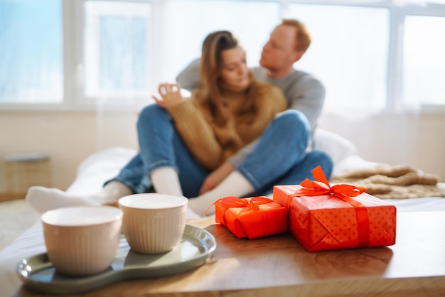 Coppia innamorata che si rilassa a casa sul letto mentre si abbracciano Concetto di vacanza di San Valentino