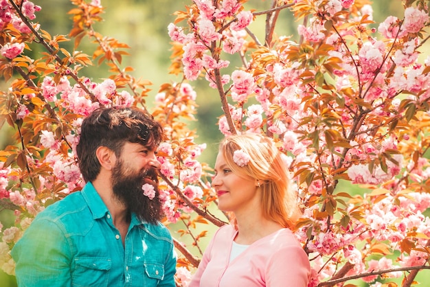 Coppia innamorata godendo rosa fiori di ciliegio primavera ritratto di bella coppia felice coppia godendo