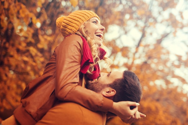 Coppia innamorata in autunno. Sorridente giovane coppia che si abbraccia nel parco.